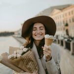 Woman Wearing Brown Coat Holding White Flower Bouquet And Ice Cream