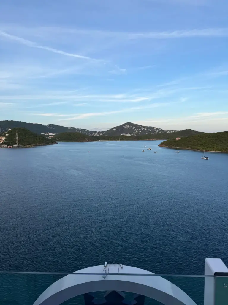 Calm blue harbor surrounded by green hills in St. Thomas, seen from a cruise ship